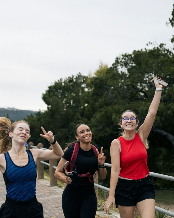 Tres amigas llenas de energía caminando al aire libre